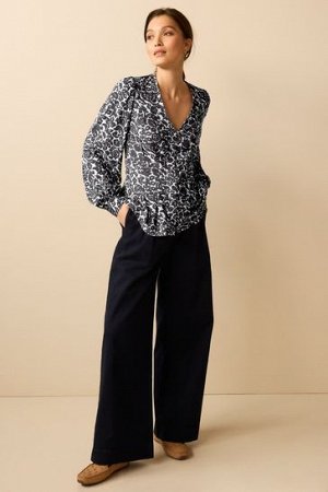 Корсетная блузка с длинными рукавами, V-образным вырезом и пуговицами.