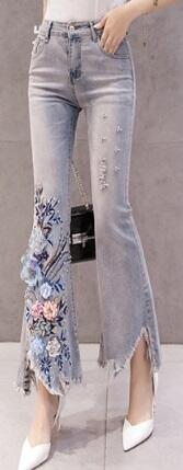 Рваные расклешенные джинсы с объемной аппликацией