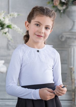 Джемма Восхитительная трикотажная блузка для девочек, выполненная из 100% хлопка. Застежка на спинке на пуговицу. Украшением блузки является пышный кружевной воротник с брошью.