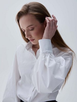 Рубашка Рубашка из хлопка с объемным рукавом. Свободная модель со спущенной линией плеча.  Рукава расширены к низу на манжете, воротник рубашечный на стойке.  Застежка на пуговицы и петли.
Материал — 