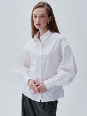 Рубашка Рубашка из хлопка с объемным рукавом. Свободная модель со спущенной линией плеча.  Рукава расширены к низу на манжете, воротник рубашечный на стойке.  Застежка на пуговицы и петли.
Материал — 