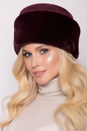 Шапка Стильная женская шапка круглой формы с декоративным отрезным дном из искусственной замши и меховым отворотом из искусственного меха (имитация – кролик). Шапка эффектно украшена цветком из отдело