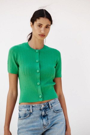 топ ЦВЕТ как на первом фото ТОП ИЗ ПУАНТЕЛЬНОЙ ВЯЗКИ (POINTELLE-STRICKTOP) Жакет с круглым вырезом и короткими рукавами. Спереди пуговицы обтянуты той же тканью. СОСТАВ МАТЕРИАЛА, ИНСТРУКЦИИ ПО УХОДУ 