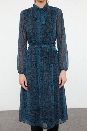 Зимнее платье из шифона с изумрудно-зеленым принтом и деталями на поясе.