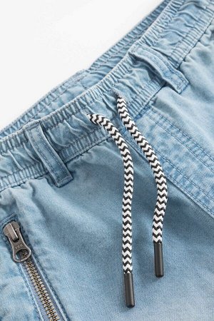 Брюки Джинсовые брюки-джоггеры с прилегающими рип-манжетами для мальчика. Мягкий эластичный пояс дополнен контрастными шнурками-завязками и шлевками для ремня. Модель имеет два врезных кармана на молн