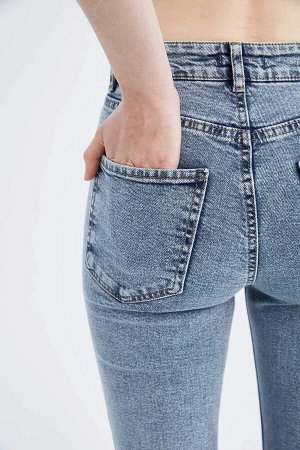 Джинсовые брюки узкого кроя с высокой талией и рваными деталями