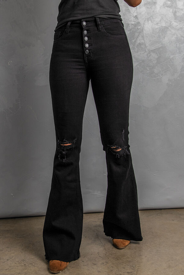 Черные джинсы-клеш с застежкой на пуговицах и дырками на коленях